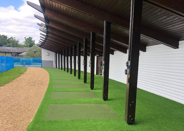 Pittsburgh Covered outdoor tee line with light green synthetic grass boxes inside a dark green synthetic grass strip